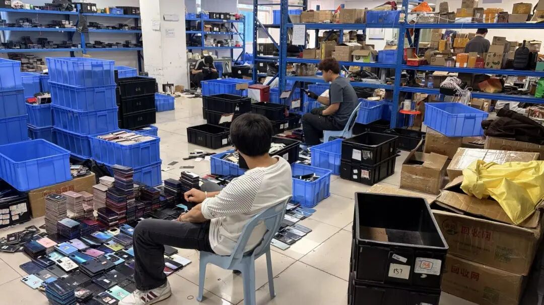 仓库中，验收二手机的工作人员。受访者供图