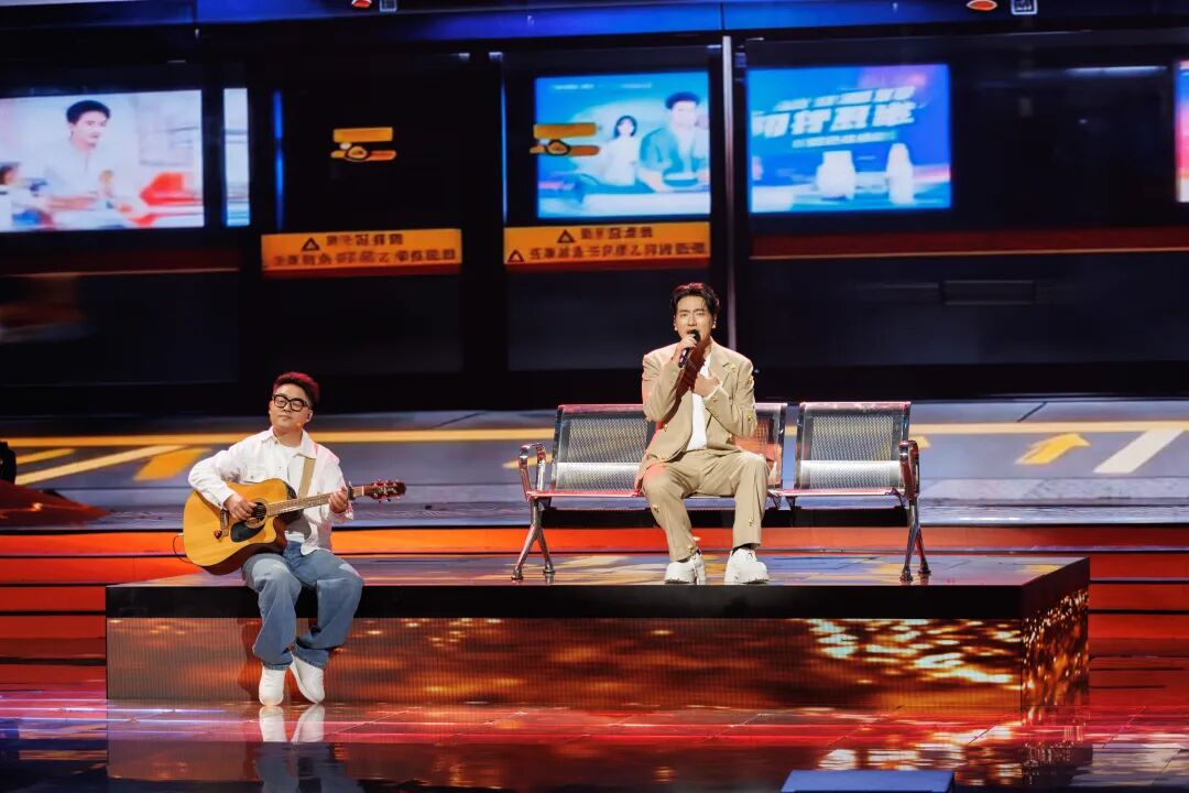 2026年湾区春晚录制现场，吴欢（左）和海来阿木（右）表演歌曲《嘉禾望岗》，舞台上搭建了广州嘉禾望岗地铁站站台的场景。（受访者供图）