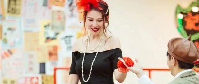 蔡少芬豁出去了，头顶大红花搭配一字肩长裙，很有民国舞女的味道