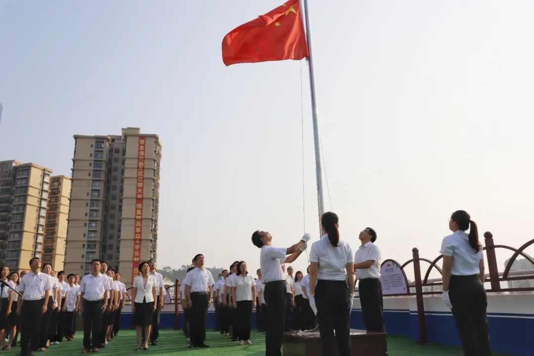 鲜艳的五星红旗冉冉升起,迎风飘扬,全体干部职工肃立,向国旗行注目礼