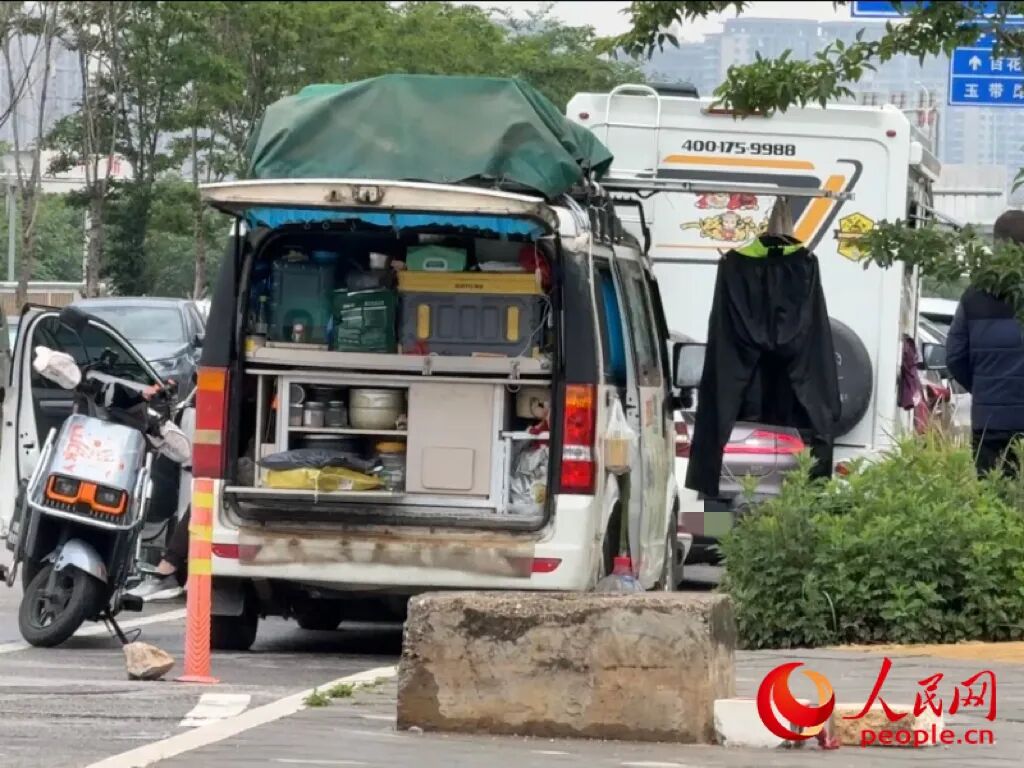 昆明市虾塘路，房车车主在路边晾晒衣物。人民网记者 蔡树菁摄