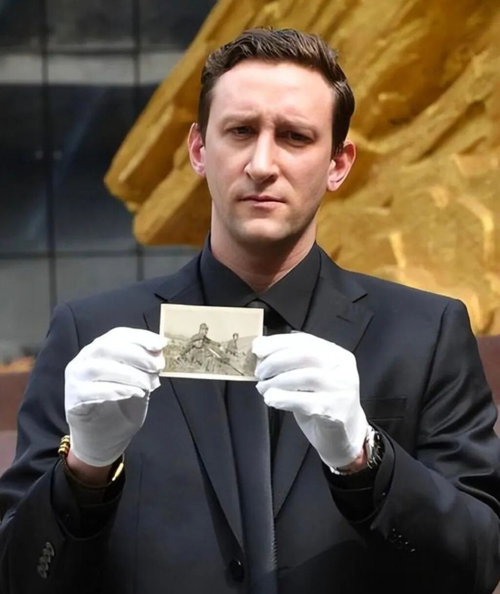 Evan Kail displays one of the historic photos of invading Japanese soldiers. Photo: www.163.com