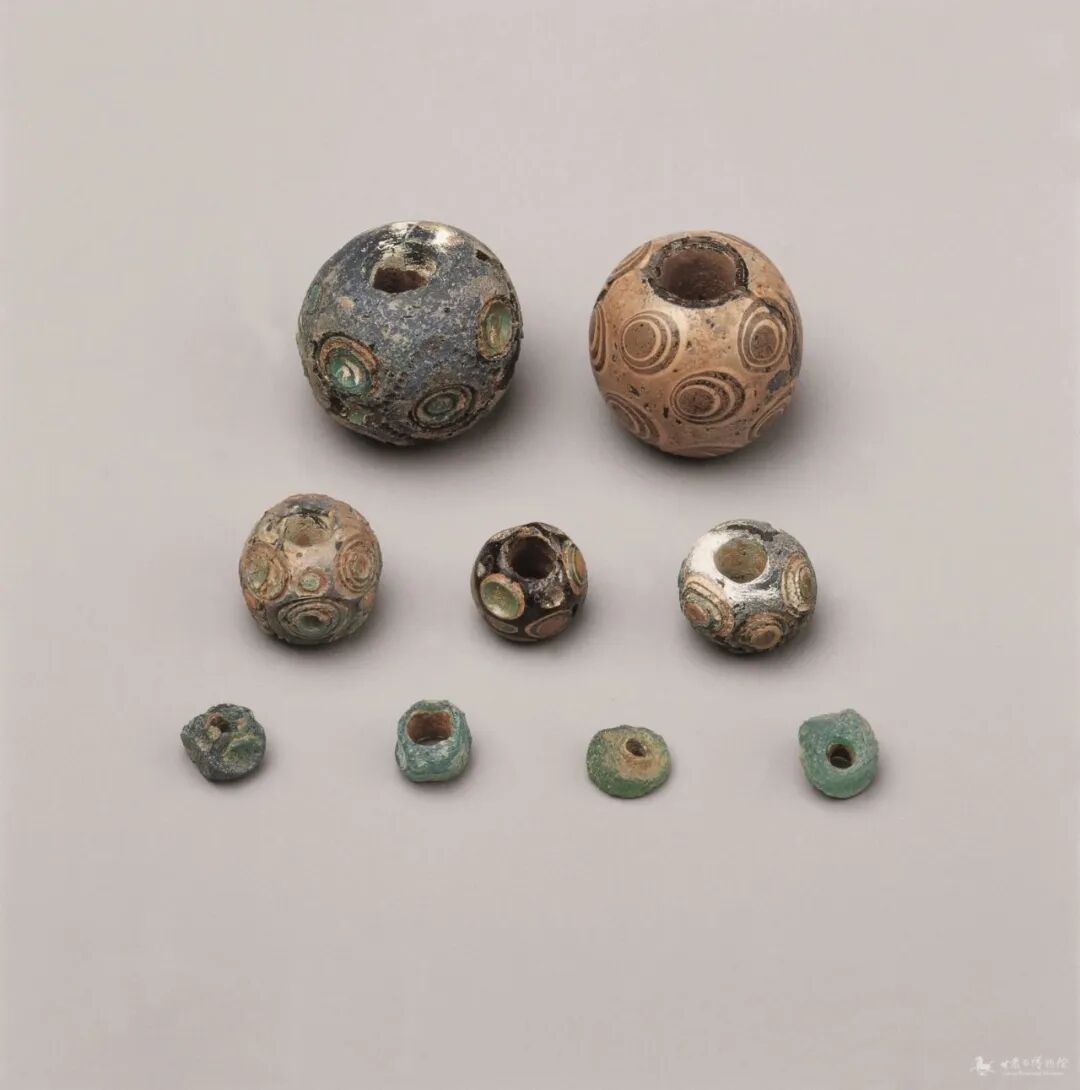 战国平凉市出土琉璃珠呈蓝色,半透明,完整珠的球面镶嵌同心圆,形似