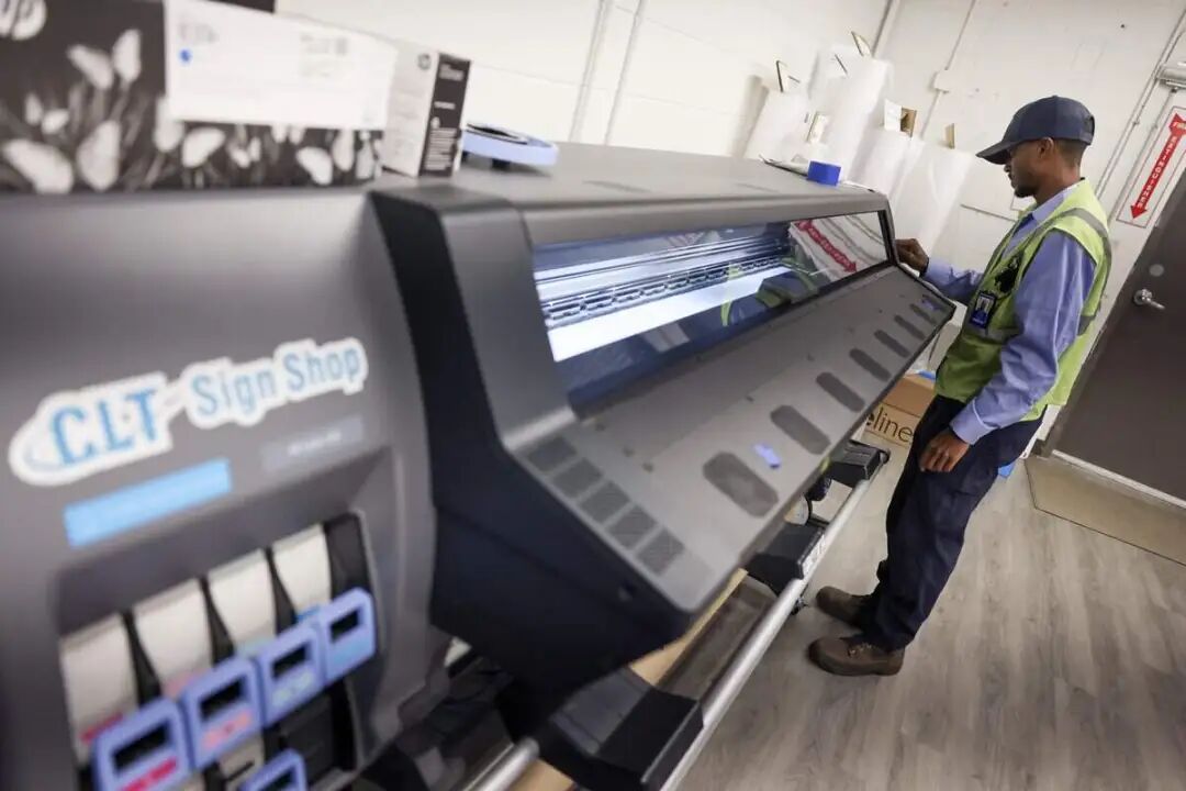 Ajani Williams, an apprentice who makes signage for the Charlotte Douglas International Airport, works with color samples on Monday, Sept. 21, 2026.
