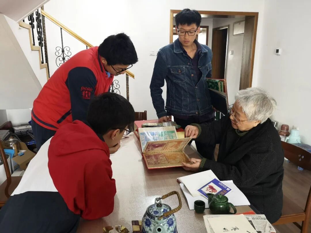 ▲ 2019年，岳同给来家看望的志愿者们展示收藏的剪纸、中国画作品