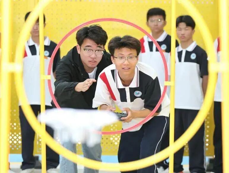 学生在老师指导下进行无人机操作实训