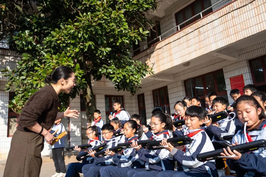 　　▲2026年1月13日，湖南益阳南县三仙湖镇中心小学，音乐老师（左一）指导学生练习口风琴 图/新华社