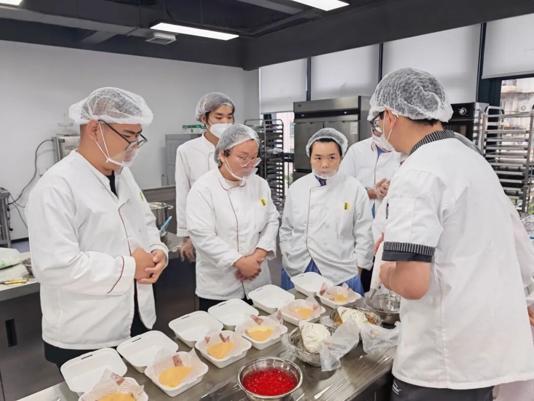 图：老师给学员们讲解装饰蛋糕要点