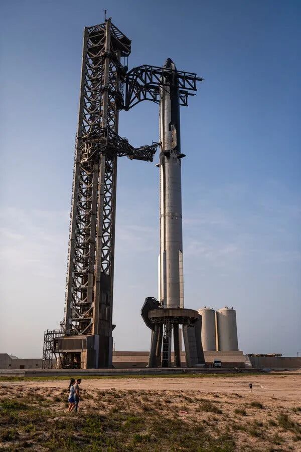 An enormously tall Starship rocket standing at a launch stand in Texas.