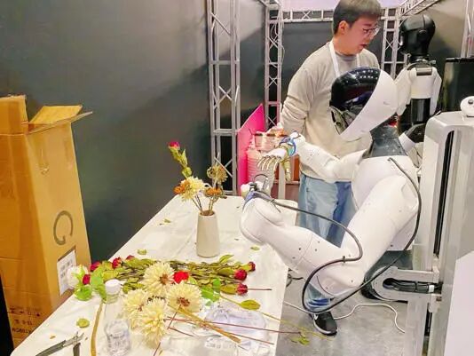 上海杉达学院参赛队的智元人形机器人精灵G1装上傲意灵巧手，正在进行登场前的最后训练热身。