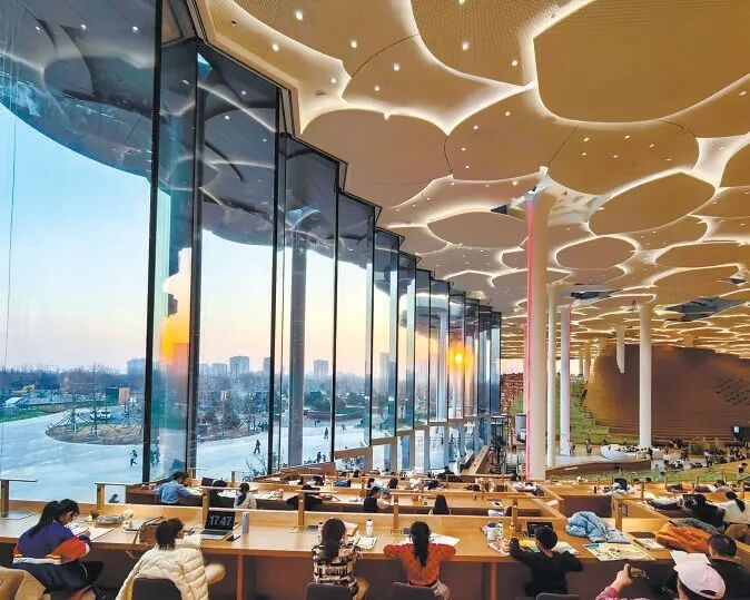 馆内阅览区座无虚席，读者沉浸在书本世界里。