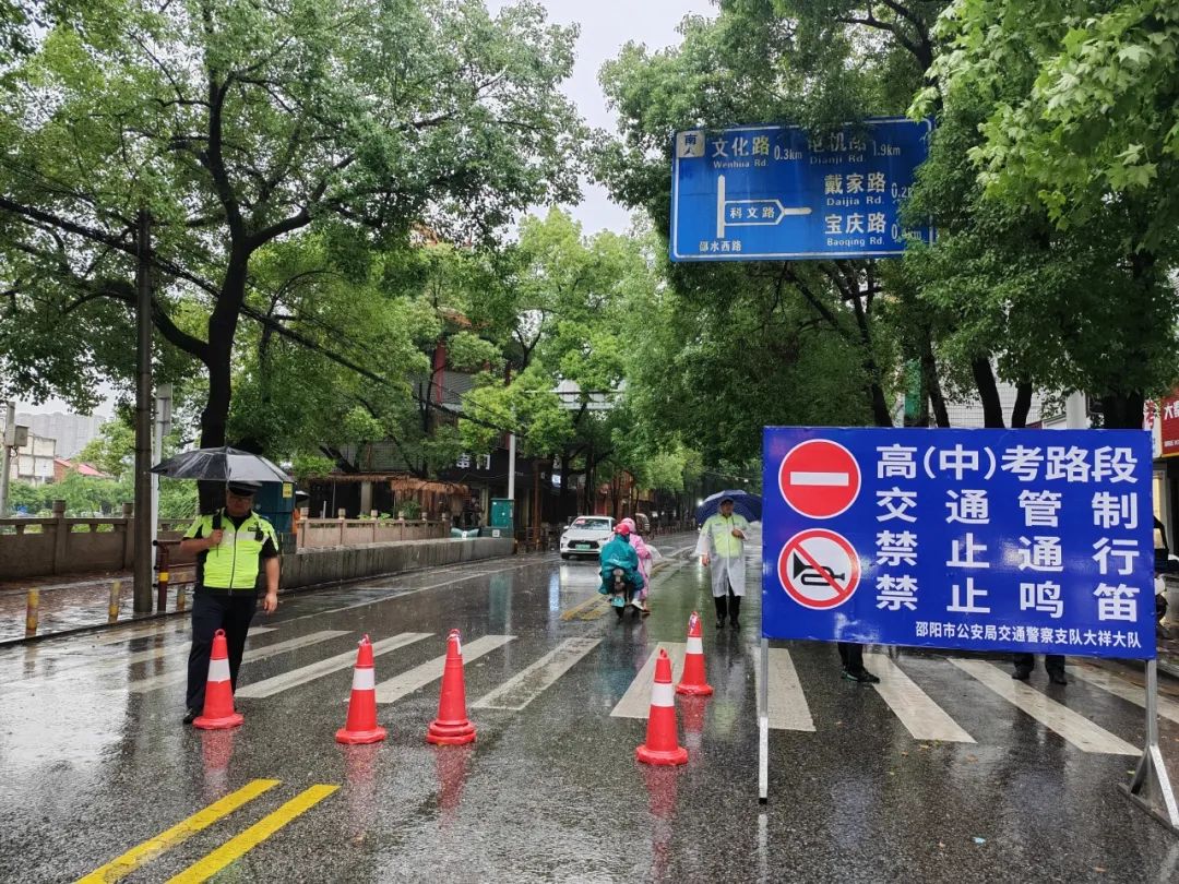 交警在大雨中为高考生撑伞
