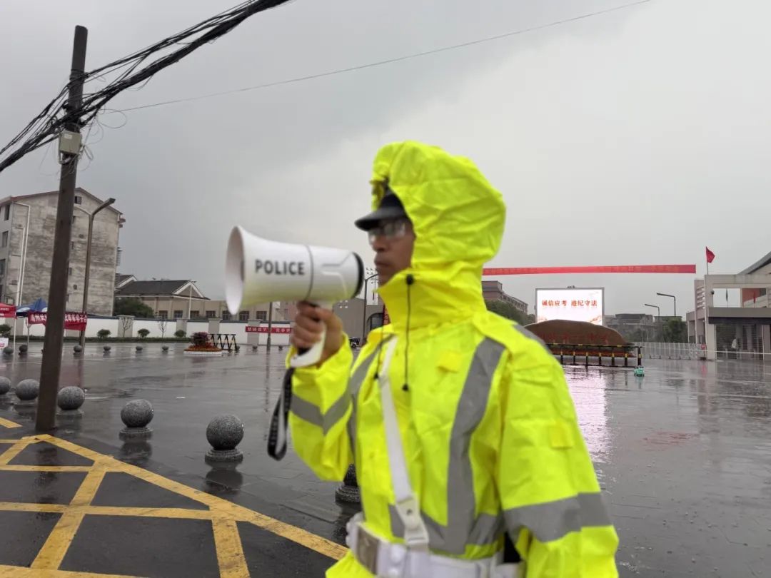 交警在大雨中为高考生撑伞