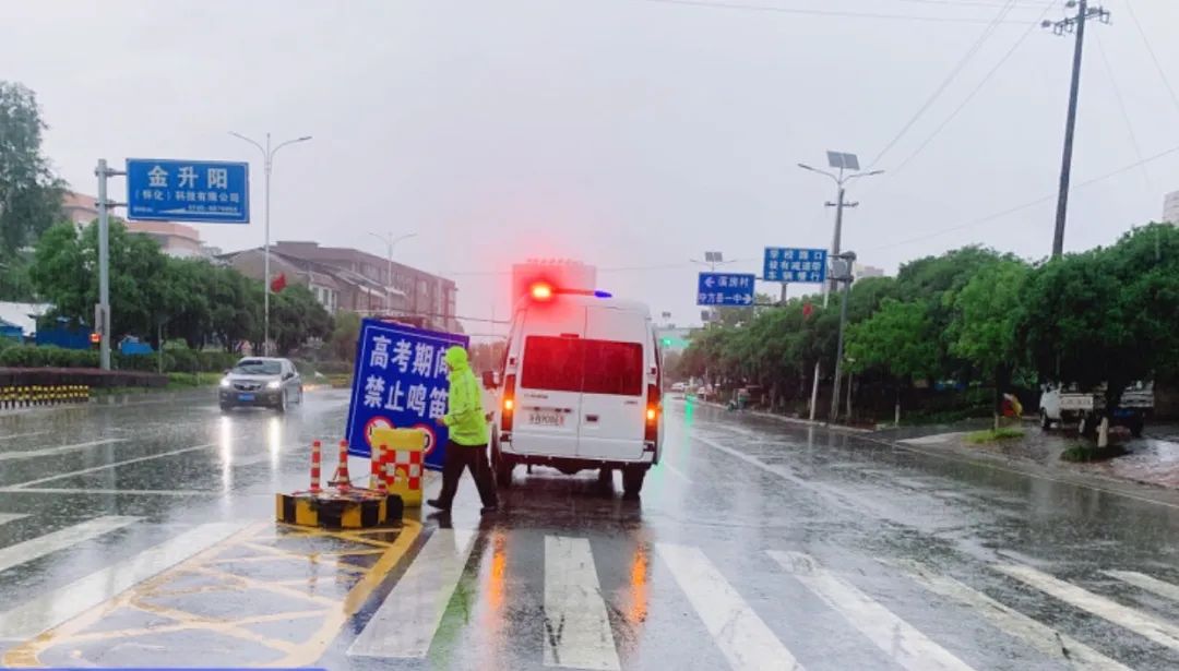 交警在大雨中为高考生撑伞