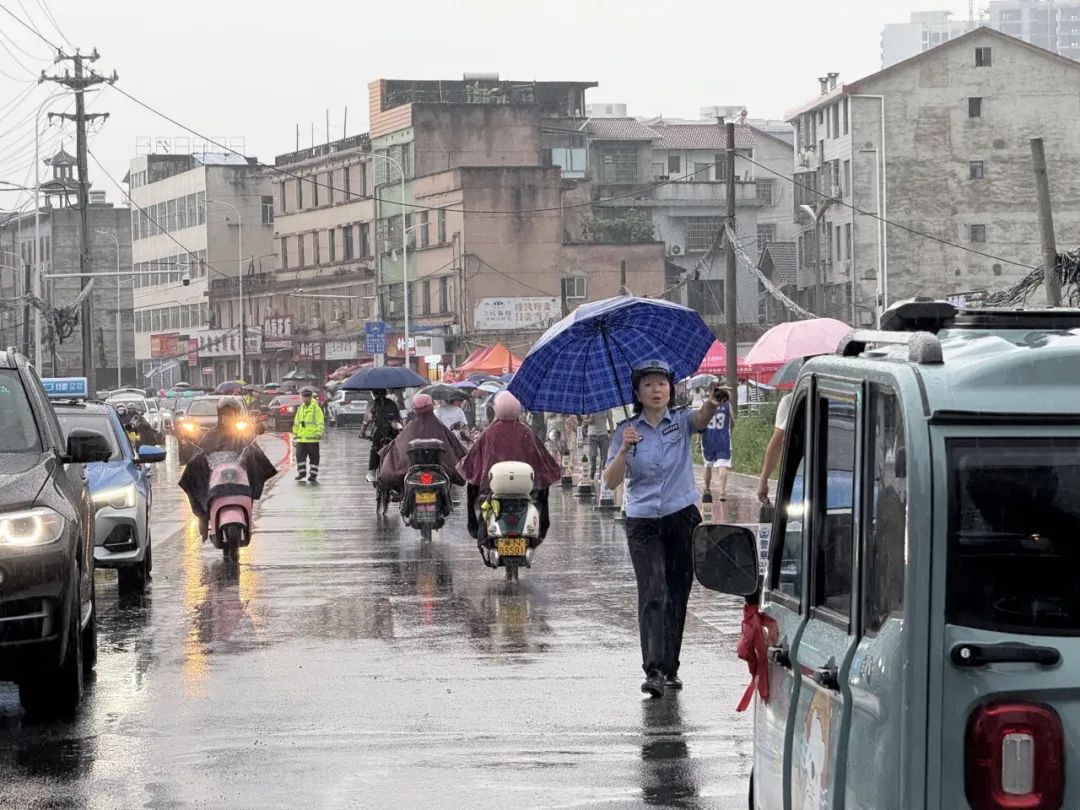 交警在大雨中为高考生撑伞