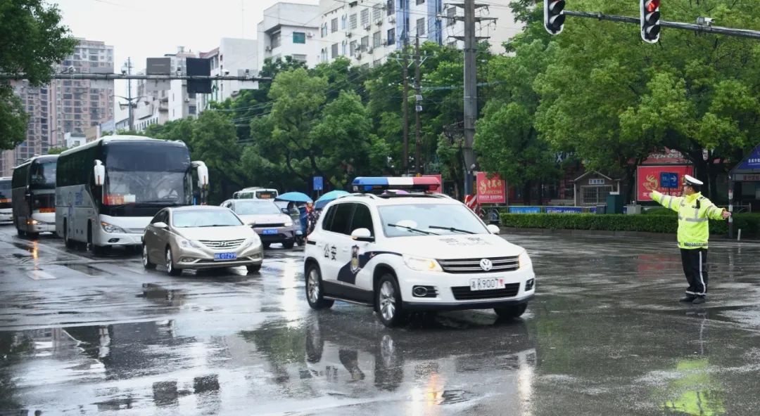 交警在大雨中为高考生撑伞
