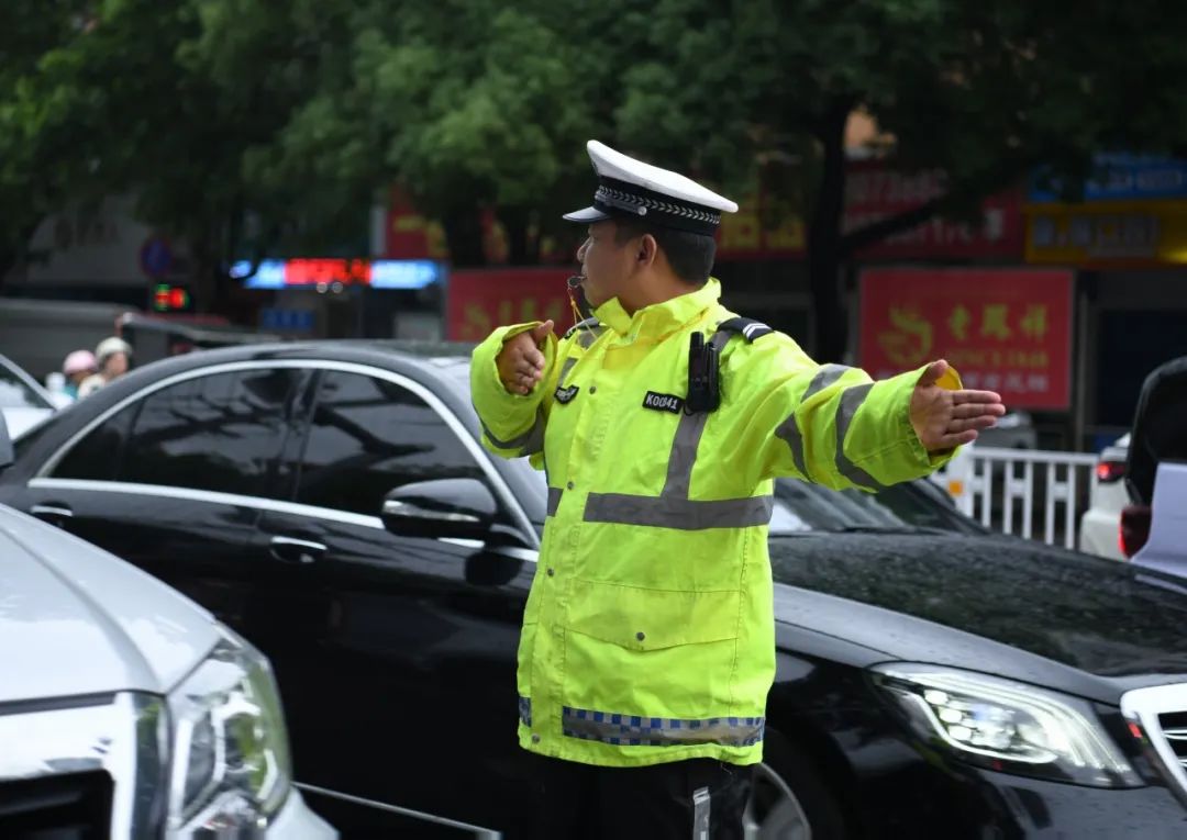 交警在大雨中为高考生撑伞