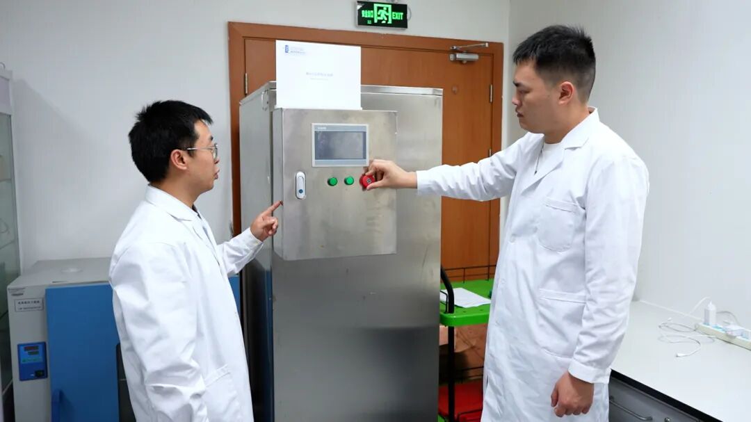 朱龙潜（左一）与同事讨论制冷系统。李卓轩摄