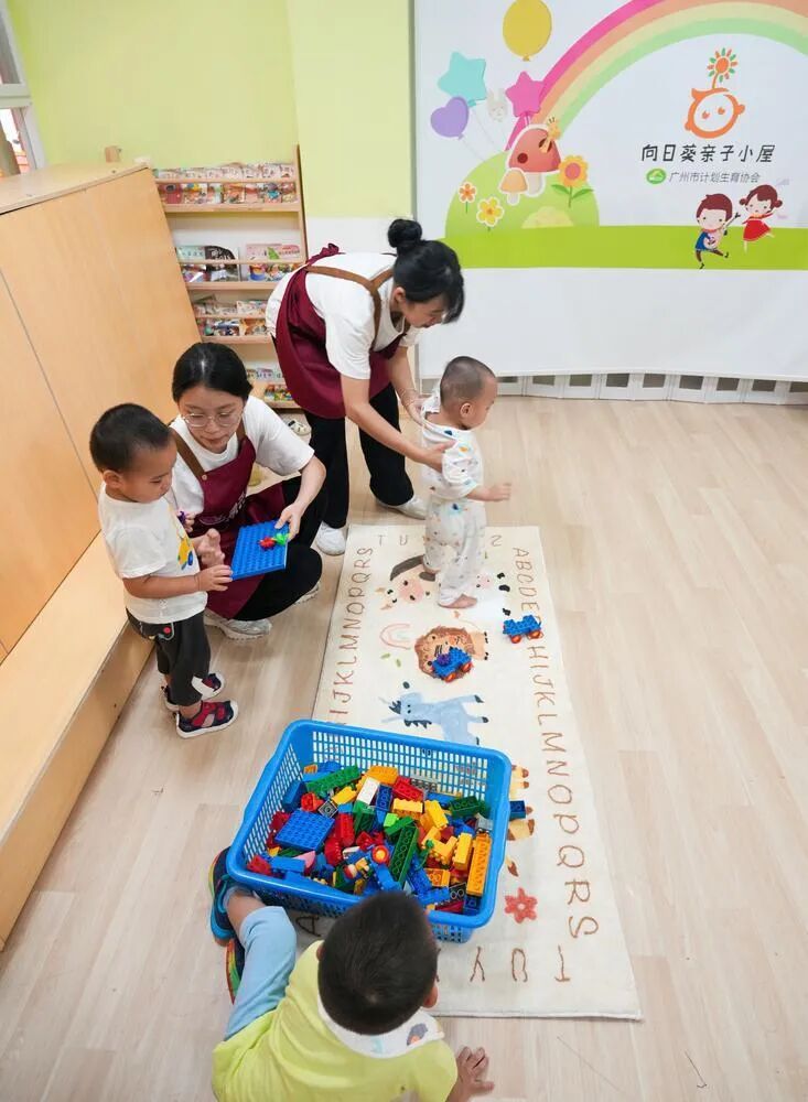 ▲普惠托育园老师和首批入读的幼儿一起做游戏。