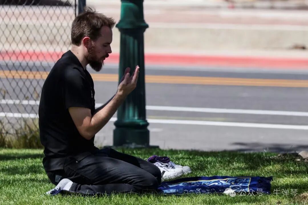 一名男子在柯克被枪杀的地点附近祈祷。