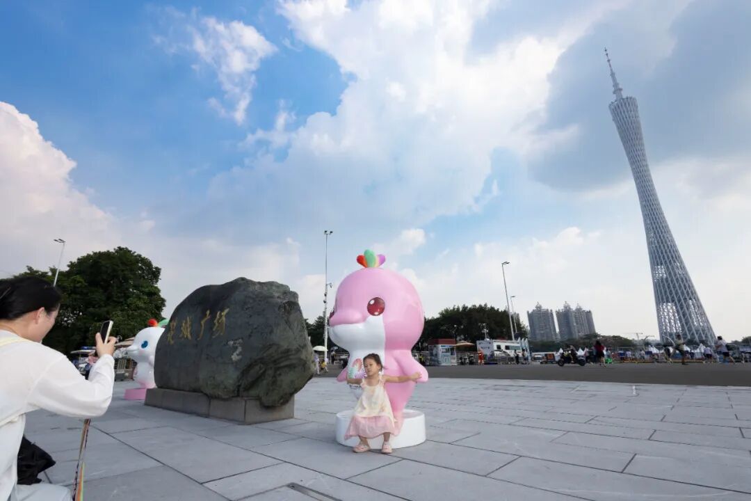 花城广场，市民在吉祥物前与广州塔合影。图/GZphotos