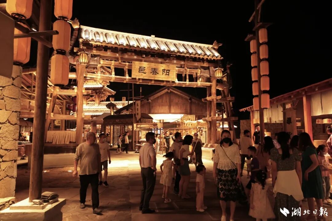 夜幕降临，莫愁村阳春邑的入口处，市民或驻足欣赏，或结伴而行。.jpg