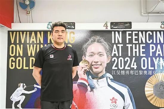 陈伟劲在江旻憓夺冠海报前留影