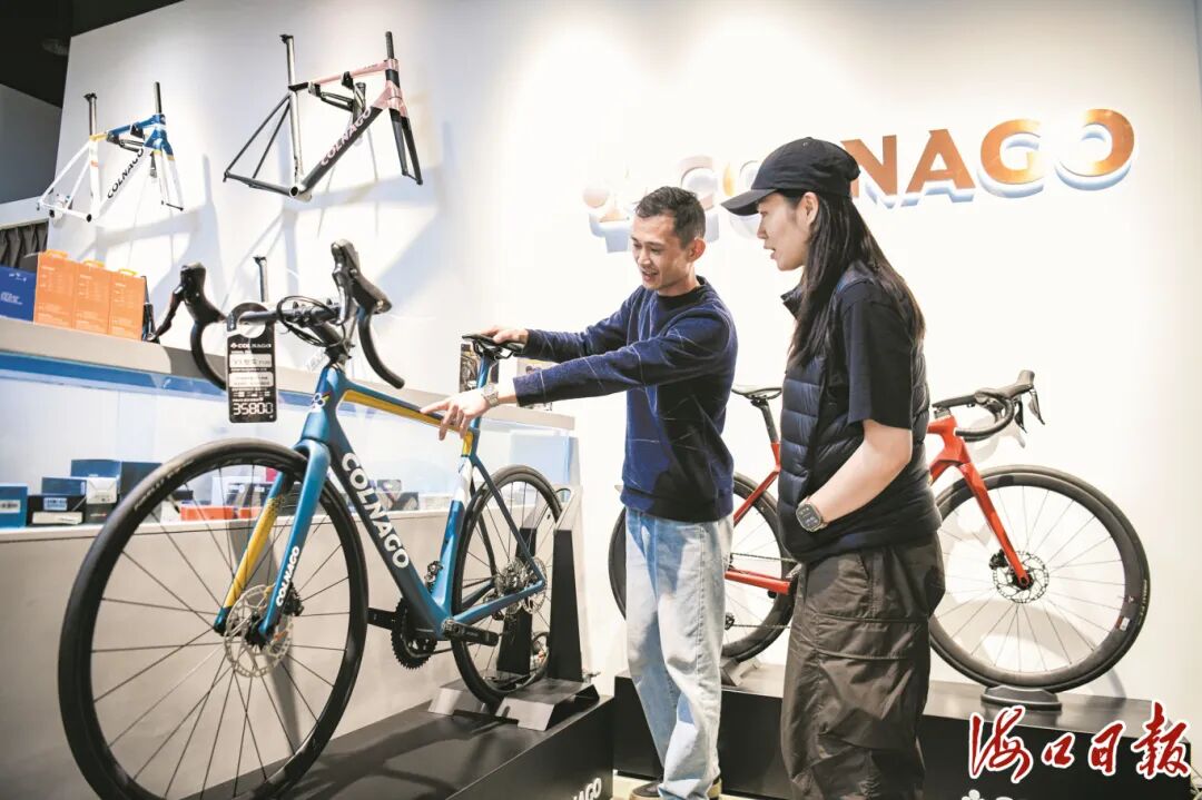 海口万象城引进世界十大顶级公路自行车品牌梅花Colnago，图为2月25日，来自杭州的骑行爱好者正在了解自行车产品。海口市融媒体中心记者 苏弼坤 摄