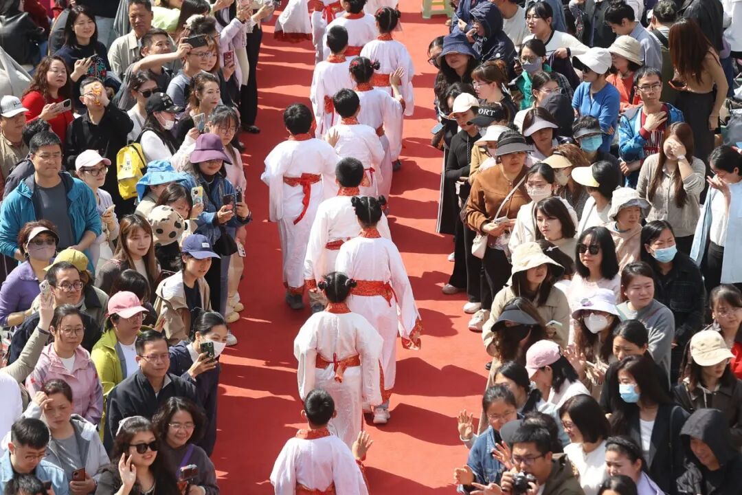 ▲2026年4月25日，江苏南京，夫子庙小学举办以“珍惜时光 知恩立志”为主题的成童礼仪式，家长们迎接孩子们入场 图/中新社记者 泱波