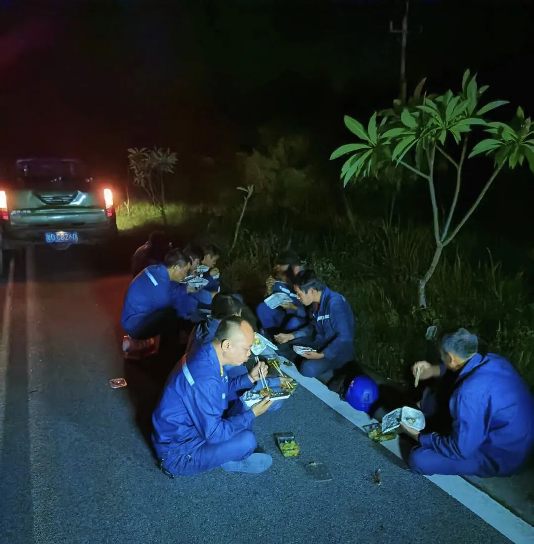 6月14日夜晚，东方供电局工作人员正对10千伏红兴线开展抢修作业，没来得及吃晚饭的抢修人员席地而坐，就着微弱的车灯，聚在一起享用了一顿“户外野餐”。（周志敏）.jpg