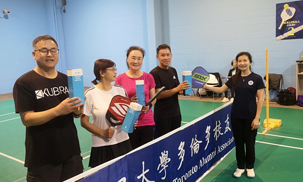 A group of people holding paddles and rackets  AI-generated content may be incorrect.