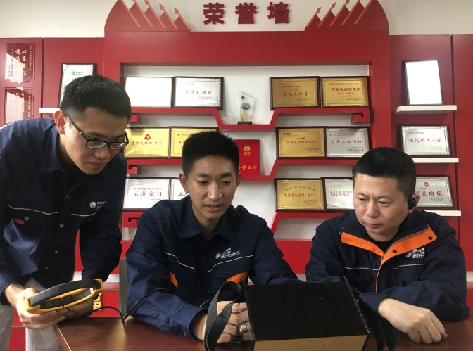 刘传波（中）与同事聚焦技术攻关，研讨创新方案。
