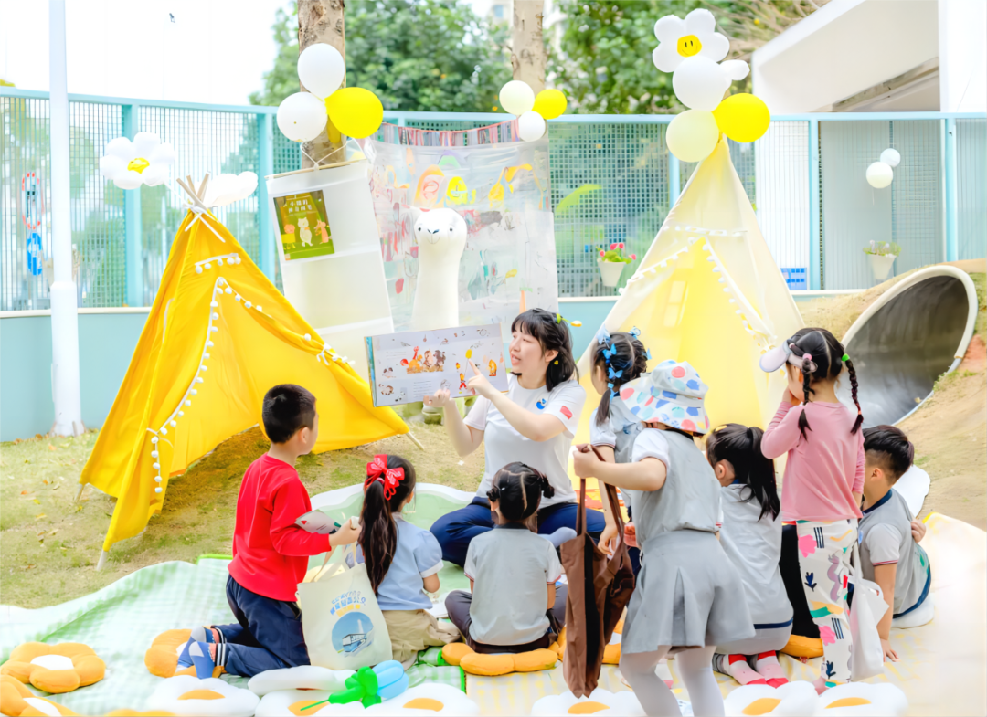 横琴伯牙幼儿园内，老师正在户外给同学们念绘本。.png
