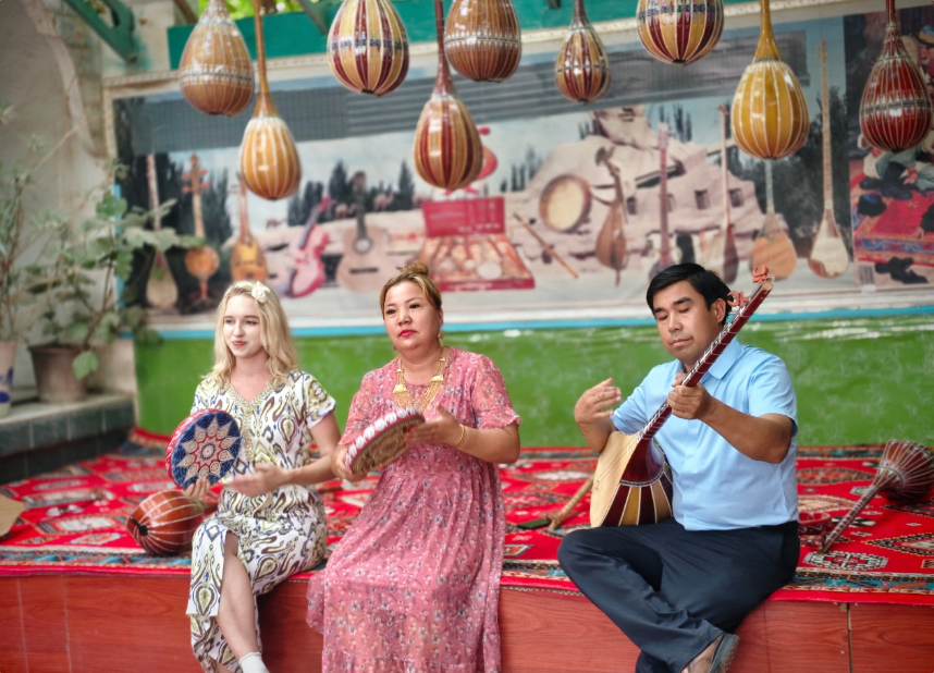 俄羅斯網(wǎng)絡(luò)達(dá)人梅麗莎（左一）正在體驗(yàn)手鼓。呂路萍 攝