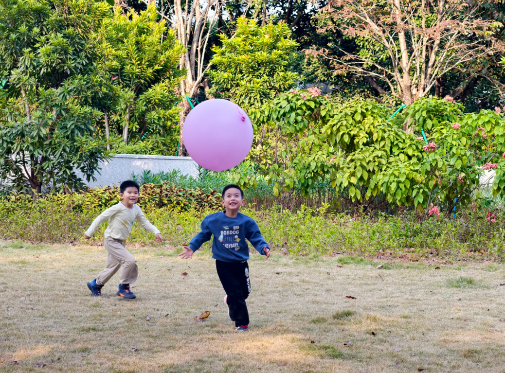 小朋友在二沙岛草地上玩气球。图/广州日报新花城记者：骆昌威