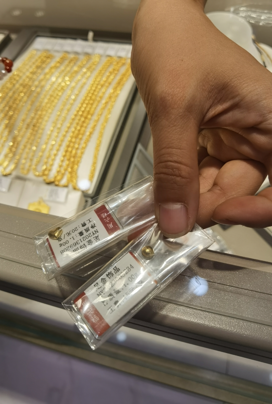 图为一门店销售人员展示金豆产品。新华社记者马晓媛 摄