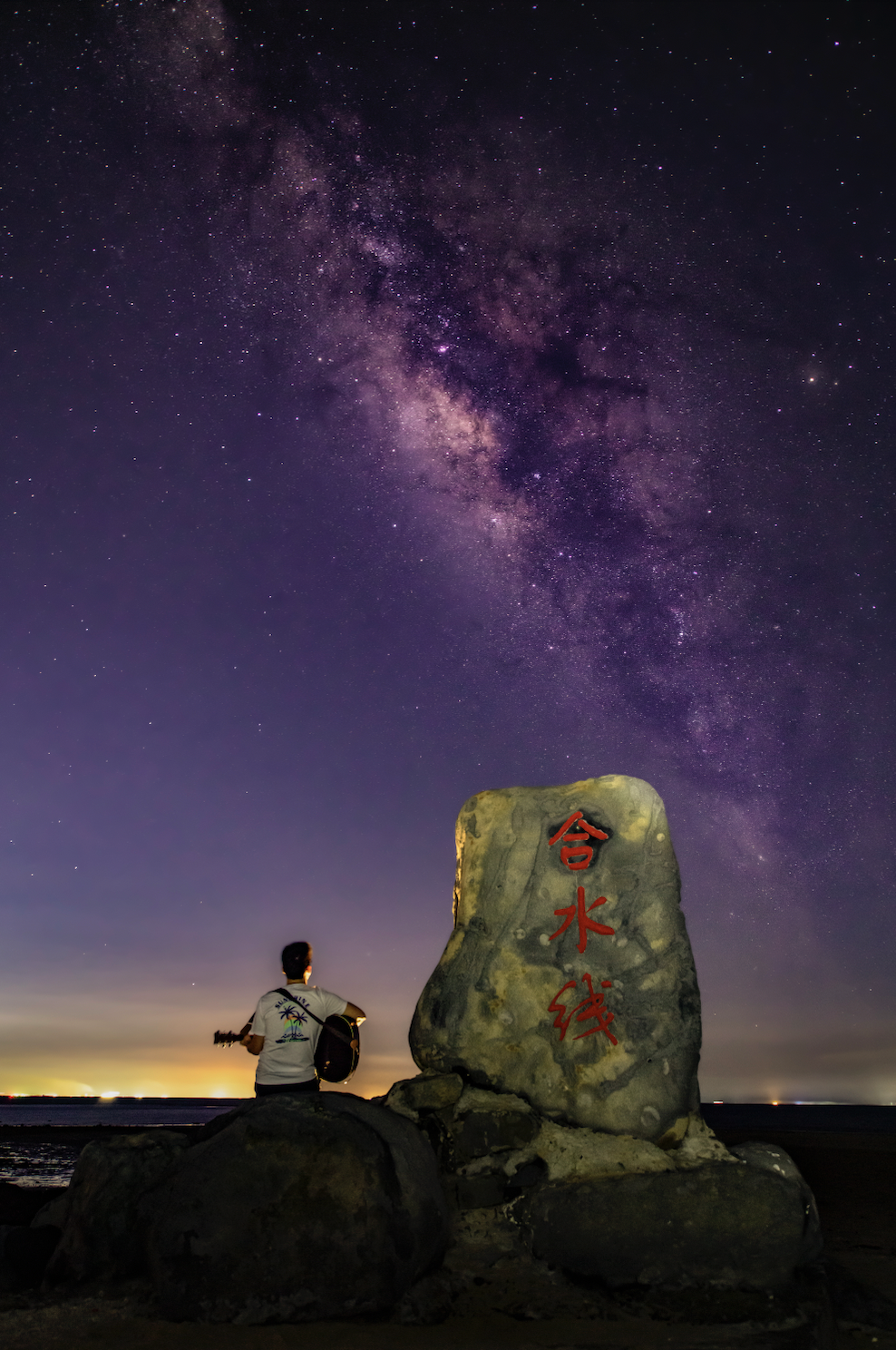 艺术家在合水线的星空下弹吉他。