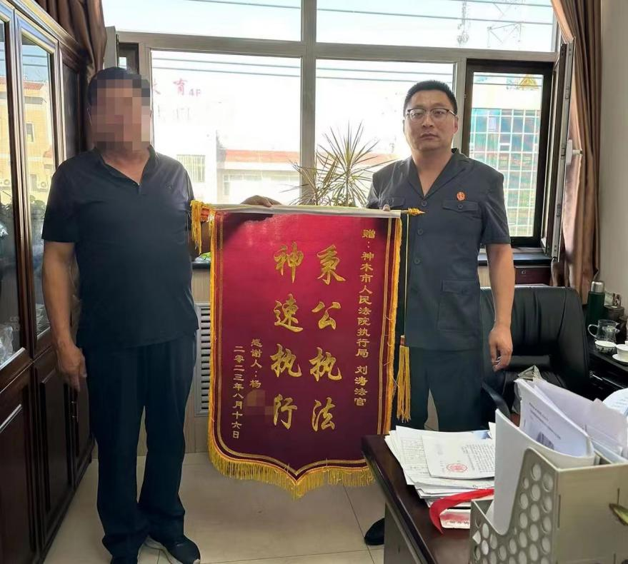 神木市法院执行局执行干警刘涛手上，感谢执行干警帮其成功追回了案款。据了解，单某和高某是两起民间借贷纠