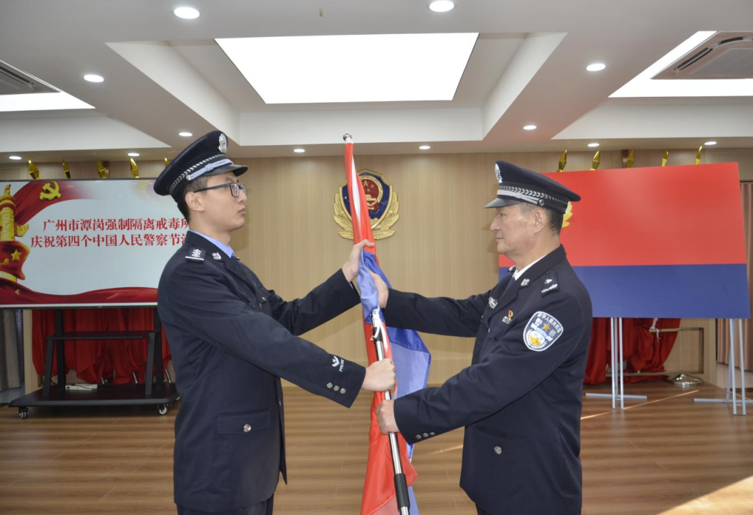 广州市潭岗所荣休民警向青年民警交接警旗，两代潭岗人完成了使命的传递