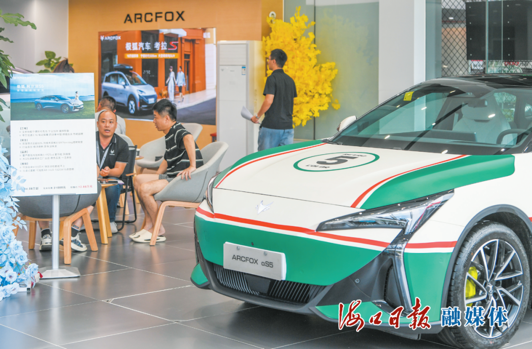 位于南海大道的一家汽车销售店内，消费者正在向销售人员咨询心仪的新能源车型。海口日报融媒体记者 康登淋 摄